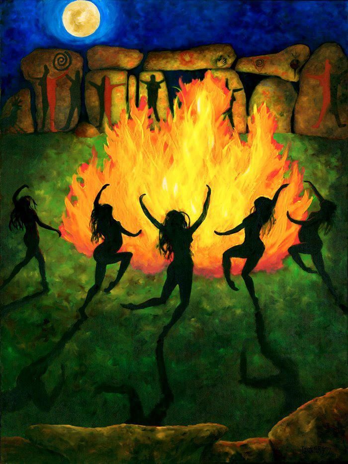 three women dancing around a campfire in front of a full moon and some rocks