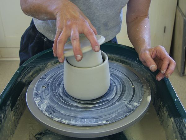 a person is spinning something on top of a machine with their hands in the air