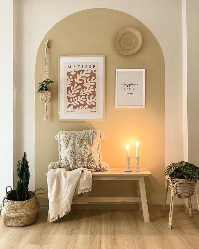 a room with a bench, candles and pictures on the wall