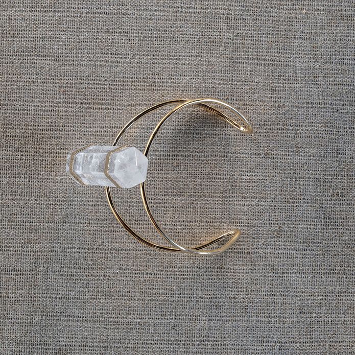 At the center of the gold-plated Wire Cuff Bracelet sits a single white crystal that is 2.5 inches in height. This striking arm band easily adjusts to the desired fit. The piece is simply stunning. SPECIFICATIONS:Approx. ½” x ½” x 2½” White Quartz Bendable cuff approx. 2½” dia This item is final sale and not eligible for return. White Adjustable Cuff Jewelry, Gold Adjustable Crystal Bangle Bracelet, Adjustable Gold Crystal Bangle Bracelet, White Crystal Bracelet, Wire Cuff Bracelet, Spring City, Wire Cuff, White Quartz, White Crystal