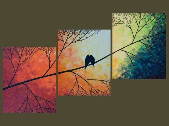 three birds sitting on a tree branch in front of colorful sky and trees with leaves