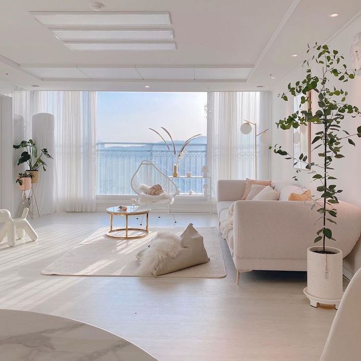 a living room filled with white furniture and lots of windows