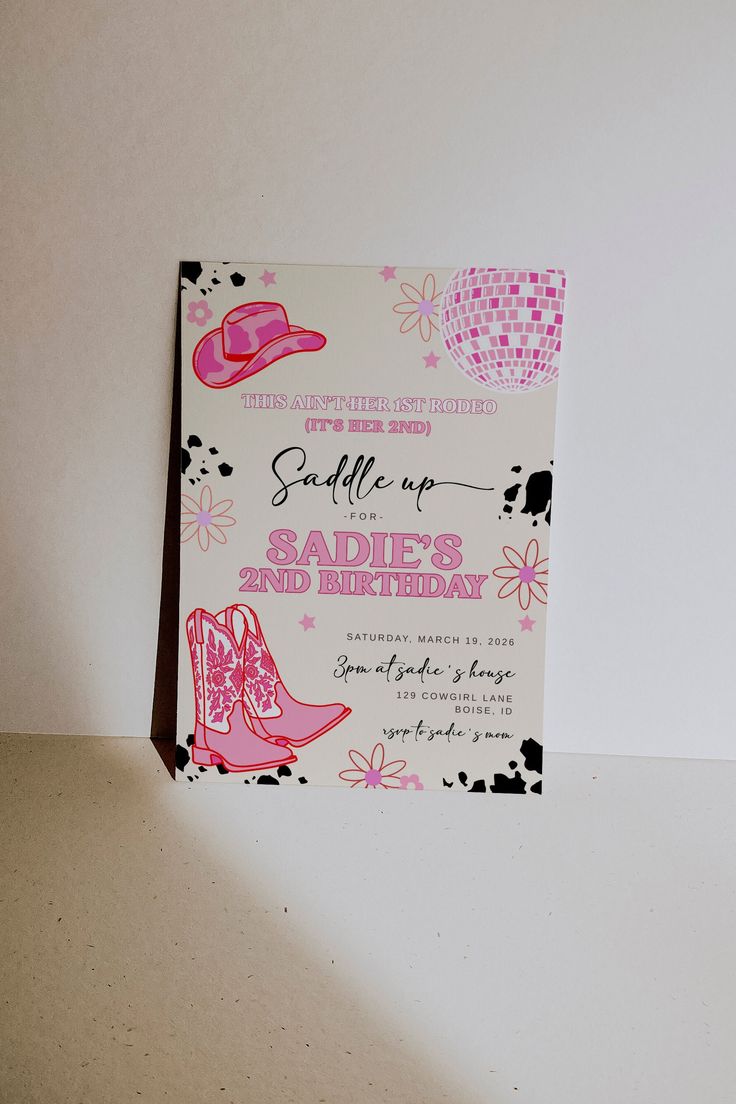 a pink and white birthday card with cowboy boots on the front, and a cowgirl hat on the back