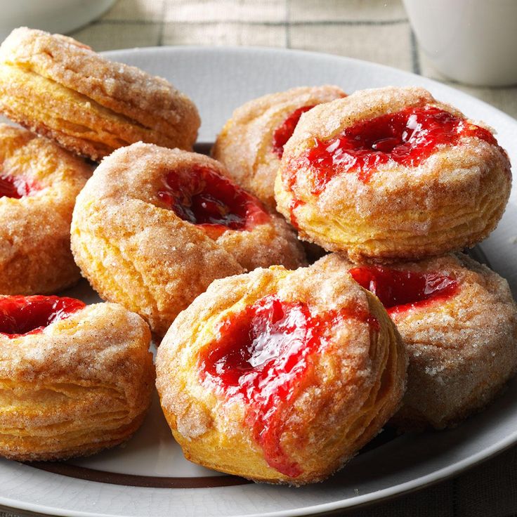 several pastries are on a plate with strawberry jam