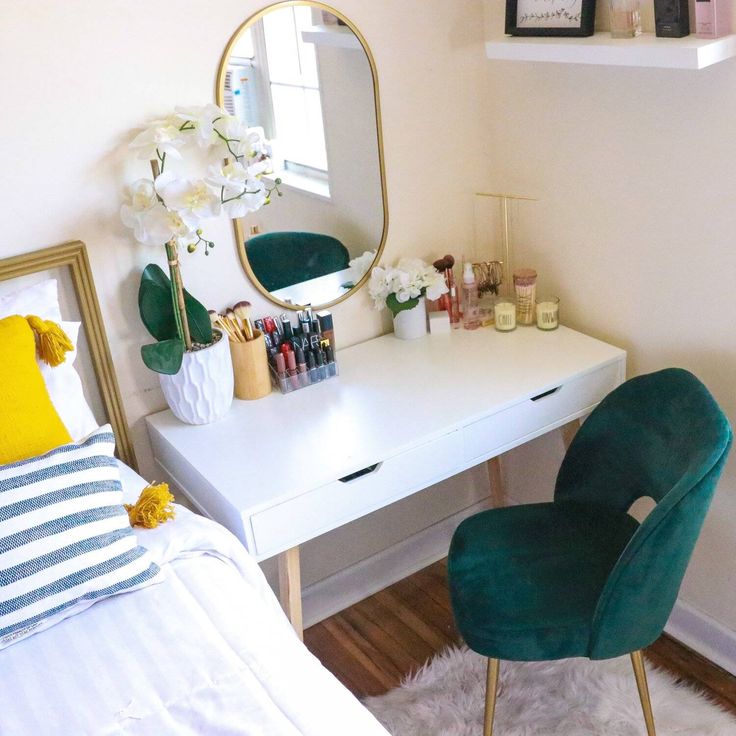 a bedroom with a white desk and green chair next to a mirror on the wall