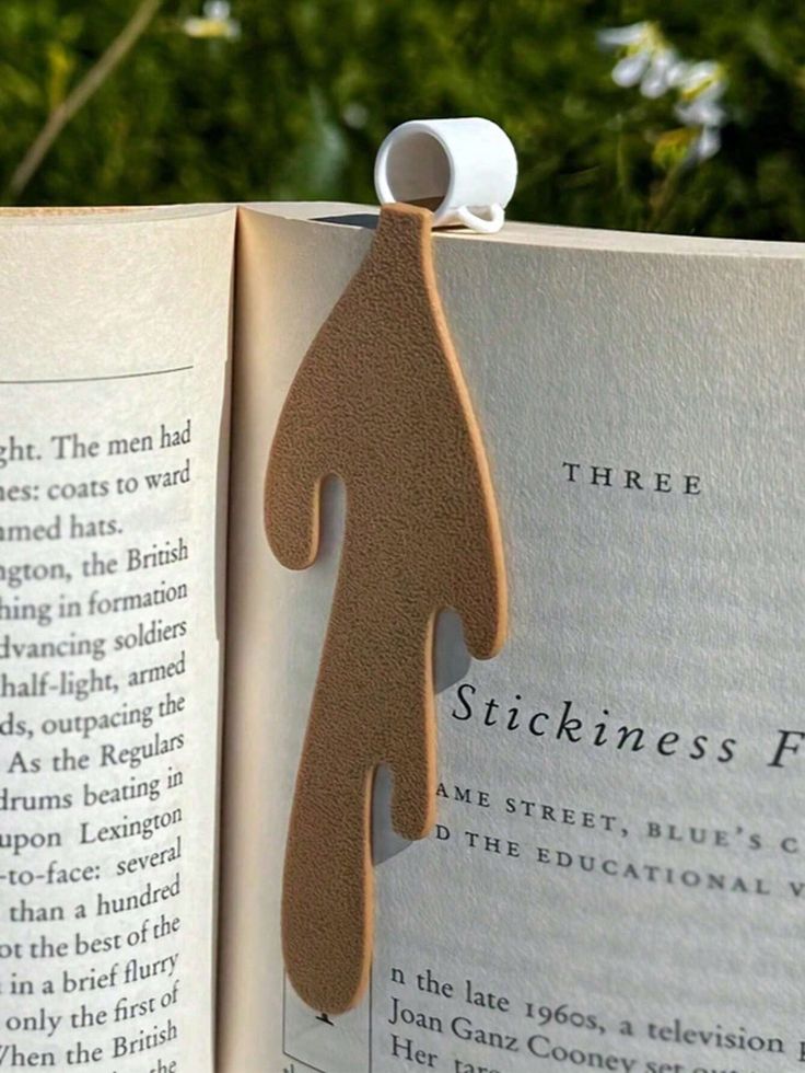 an open book with a wooden sticker on it