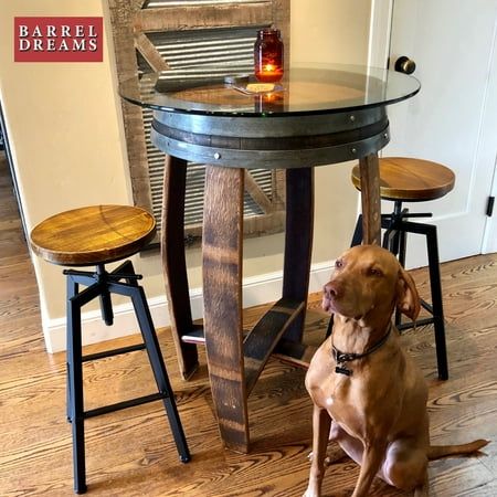 a dog sitting in front of a table with stools and a candle on it