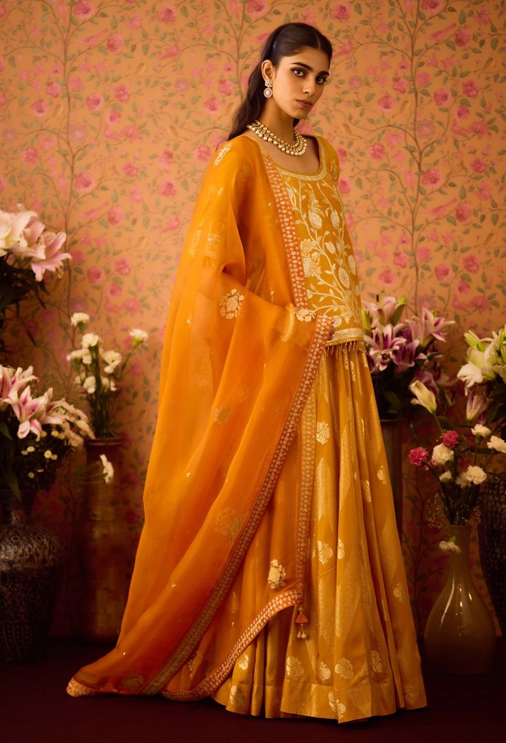 Step into refined elegance with the gold yellow appliqué silk brocade choli kurta, beautifully paired with a multi-panel brocade lehenga. This stunning ensemble showcases intricate appliqué detailing that enhances the luxurious brocade fabric, while the flowing lehenga offers a beautiful silhouette. Complemented by an embroidered dupatta, this outfit is perfect for festive occasions, blending traditional charm with modern sophistication. Gold Silk Palazzo Set With Traditional Drape, Gold Embroidered Raw Silk Palazzo Set, Gold Chanderi Palazzo Set With Traditional Drape, Gold Silk Palazzo Set For Diwali, Gold Chanderi Palazzo Set With Pallu, Gold Silk Palazzo Set With Zari Work, Gold Silk Palazzo Set With Straight Kurta, Gold Embroidered Chanderi Palazzo Set, Elegant Yellow Dola Silk Anarkali Set