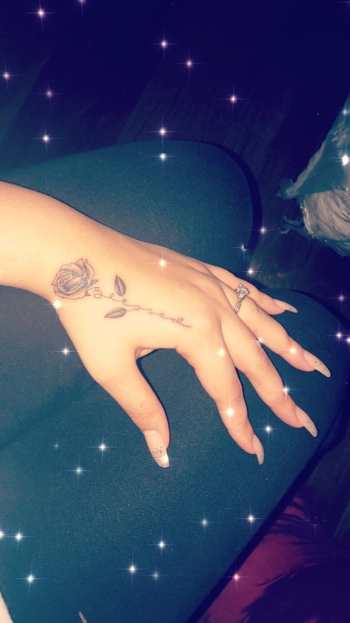 a woman's hand with a rose tattoo on it