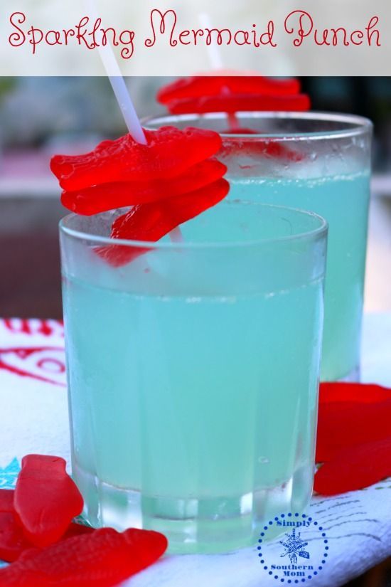 two glasses filled with blue liquid sitting on top of a table