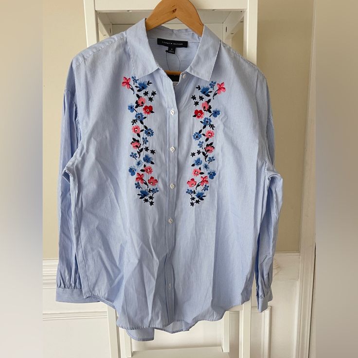 100% Cotton, Puff Sleevesdropped Should And Loose Fits. This Lovely Flower Shirt Is Perfect For Spring And Early Summer Looks. Blue Tommy Hilfiger Button-up Top, Tommy Hilfiger Blue Top For Workwear, Tommy Hilfiger Blue Top For Work, Tommy Hilfiger Long Sleeve Tops For Spring, Tommy Hilfiger Blue Spring Tops, Tommy Hilfiger Blue Tops For Spring, Tommy Hilfiger Button-up Shirt For Spring, Trendy Blue Tops With Floral Embroidery, Tommy Hilfiger Long Sleeve Blouse For Spring