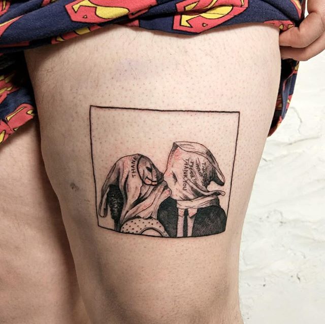 a woman's thigh with an image of two dogs on it and the bottom part of her leg