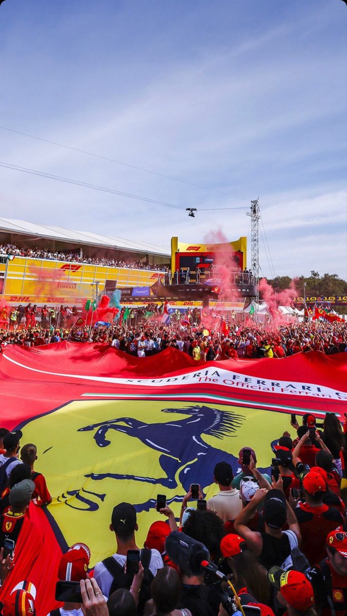 a large red and yellow flag is in the middle of a crowd at a sporting event