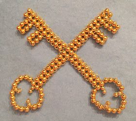 a gold beaded cross is shown on a gray surface with the letter x in the middle