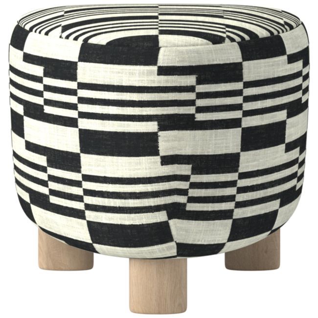 a black and white stool with wooden legs