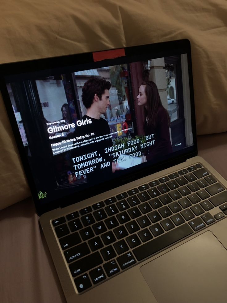 an open laptop computer sitting on top of a bed