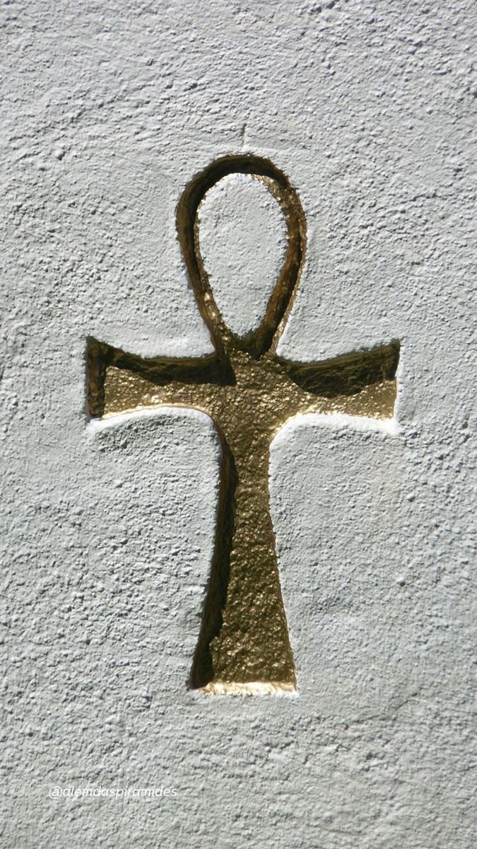 an ancient symbol is painted on the side of a white wall with gold foiling