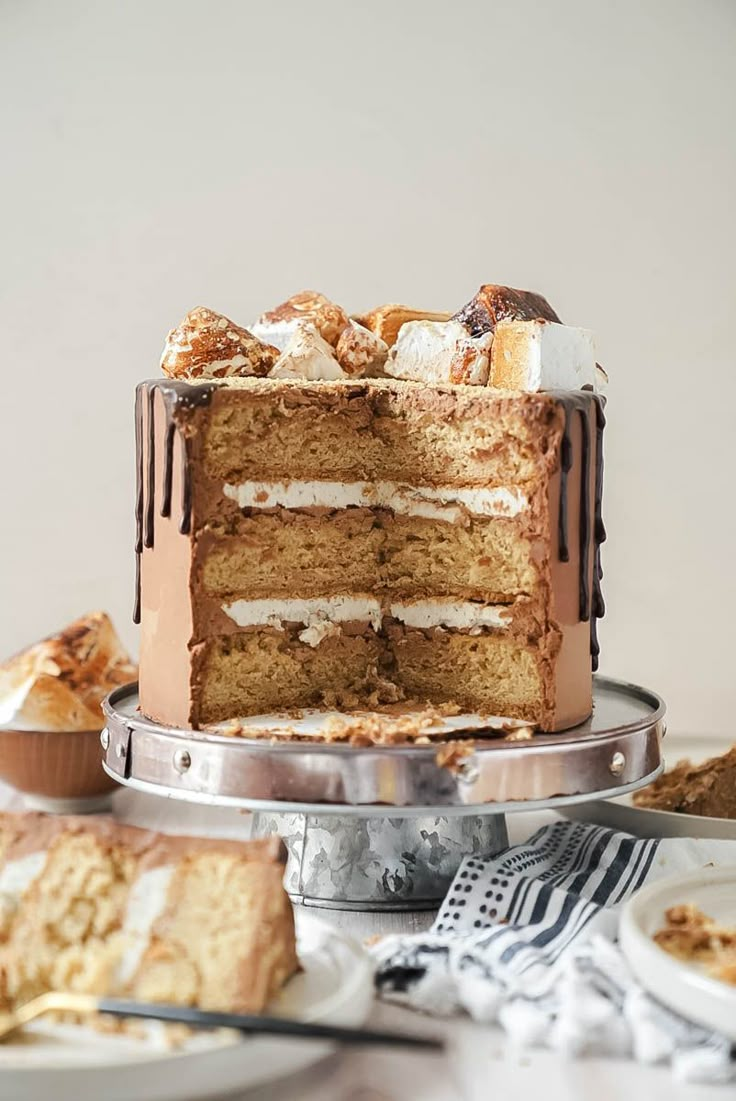 there is a cake that has been cut into pieces and served on the table with other desserts