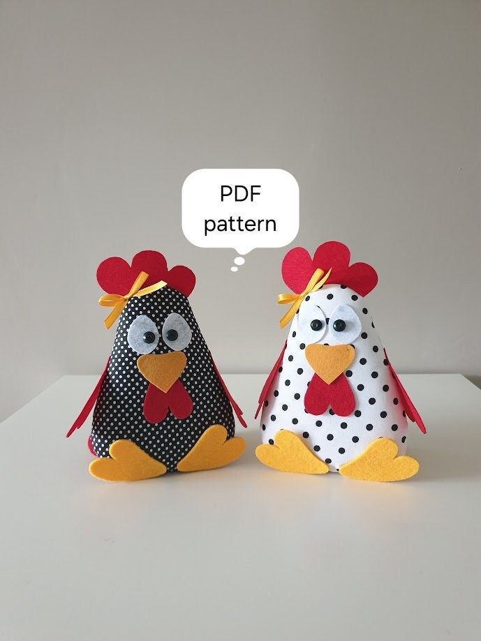 two stuffed chickens sitting next to each other on top of a white table with a speech bubble above them