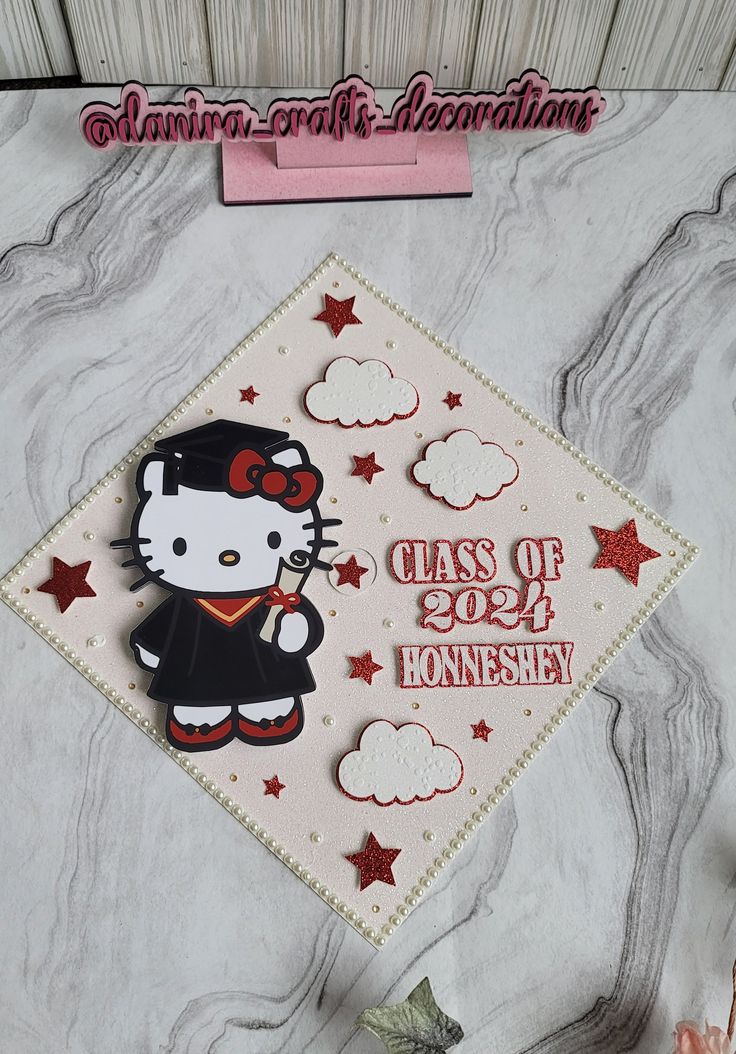 a hello kitty graduation cap with the class of 2020 written on it and red stars