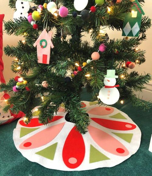 a small christmas tree with ornaments hanging from it's branches and on the ground