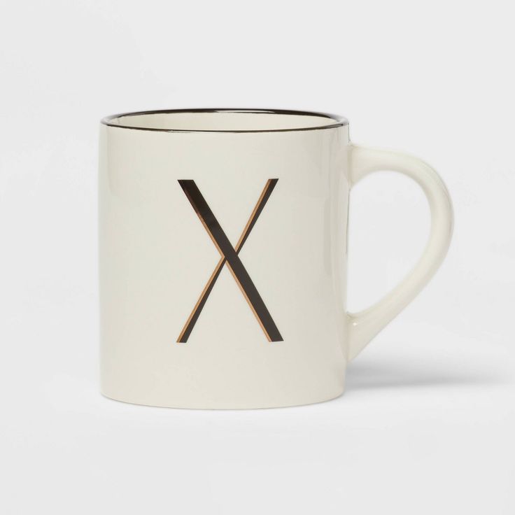 a white and black coffee mug with the letter x on it's front side