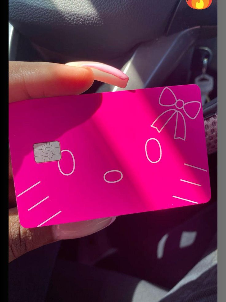 a person holding up a pink credit card