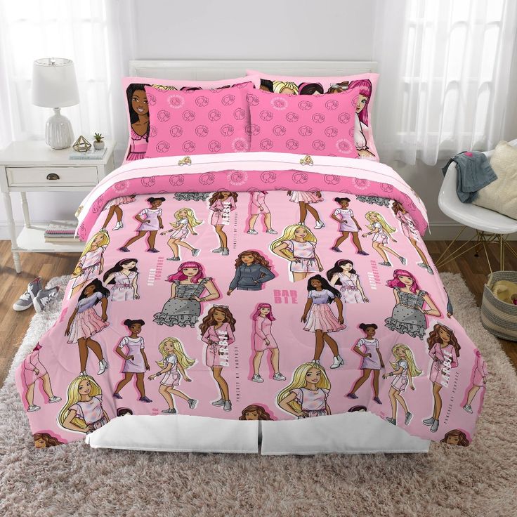 a bed with pink and white bedspread covered in cartoon character designs on it