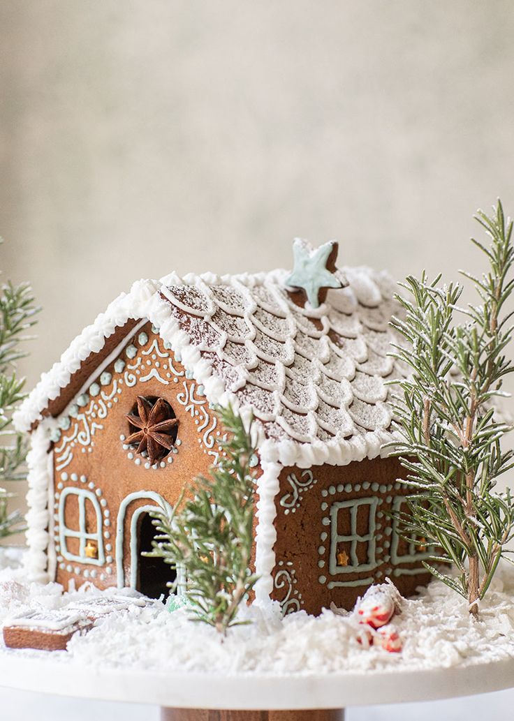 a gingerbread house is decorated with icing and snow