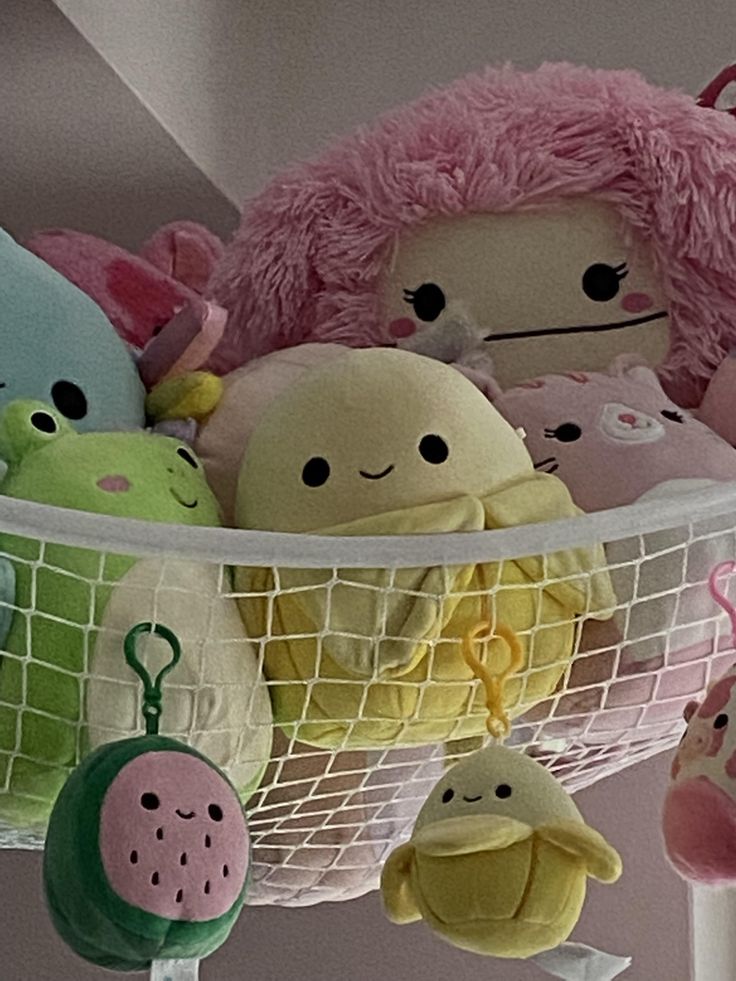 several stuffed animals in a net hanging from the ceiling