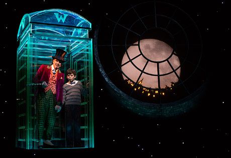 two people are standing in a glass case with the moon behind them and stars on the night sky