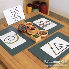 a wooden table topped with paper cut outs filled with different types of crafts and materials