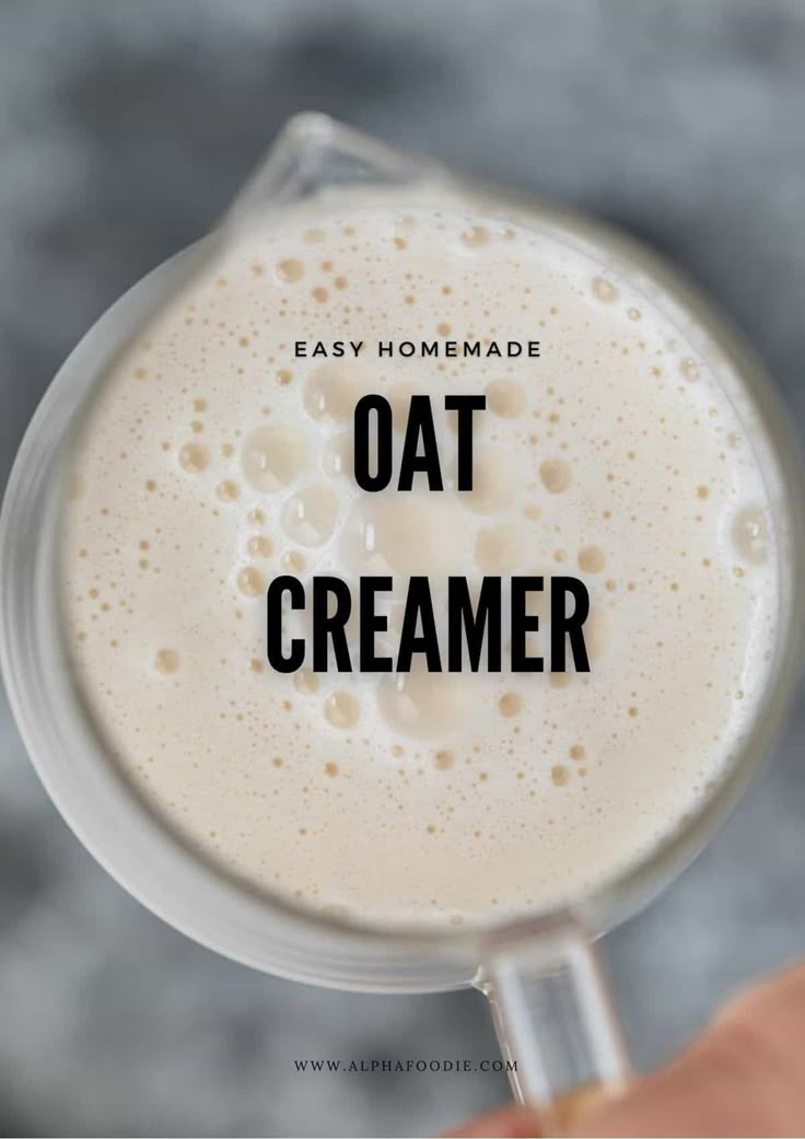 a hand holding a glass with an oat creamer in it that says easy homemade