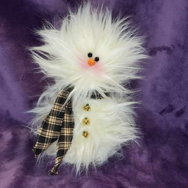 a stuffed snowman with white fur on it's head