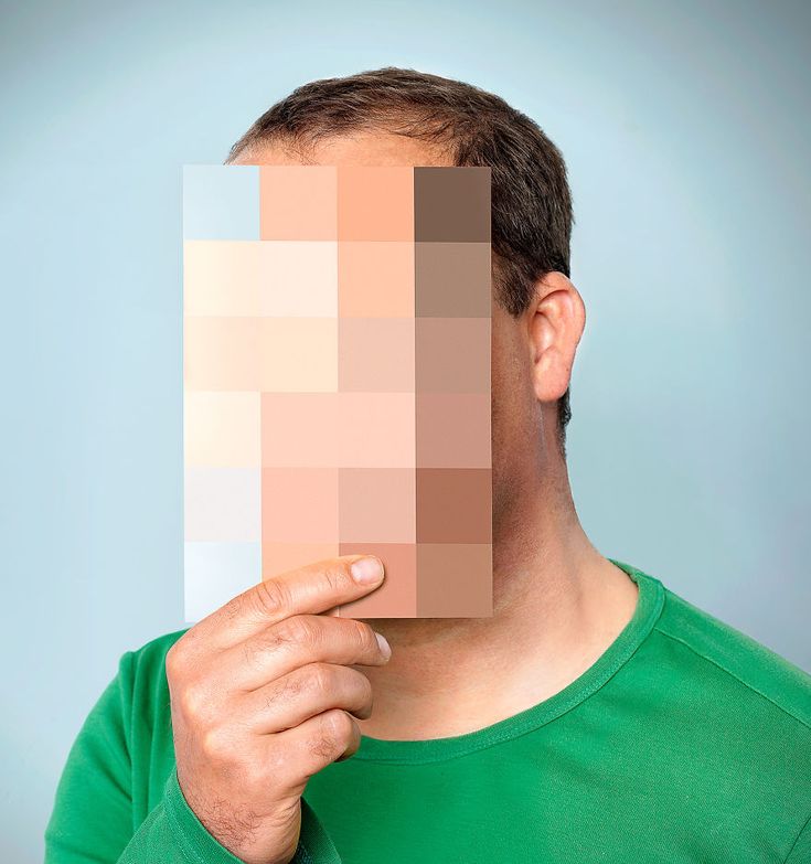 a man holding up a piece of paper to his face