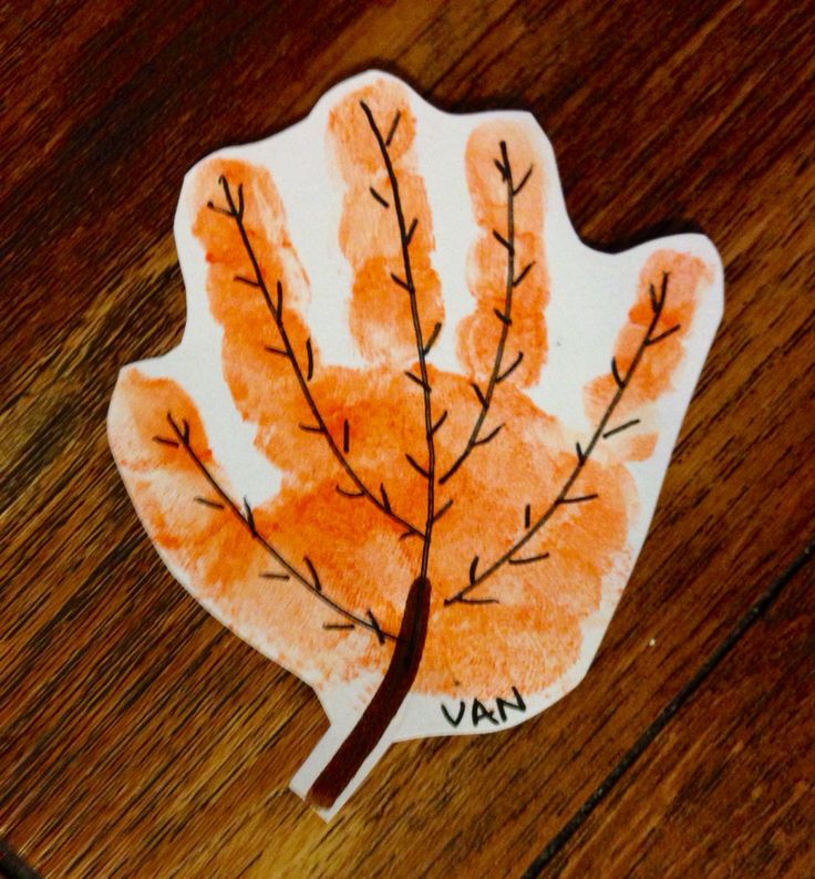 a handprinted leaf is shown on a wooden surface with the word vav written in it