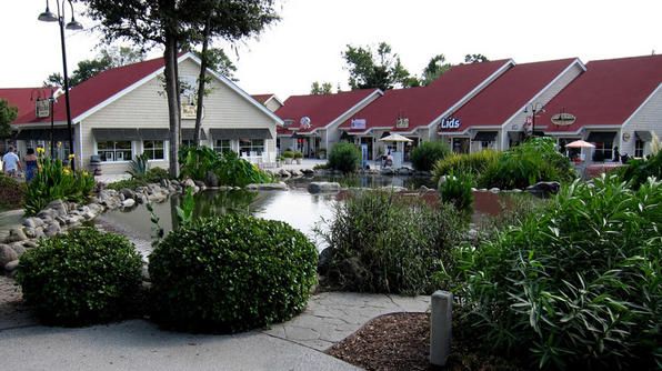 a row of houses next to a small pond