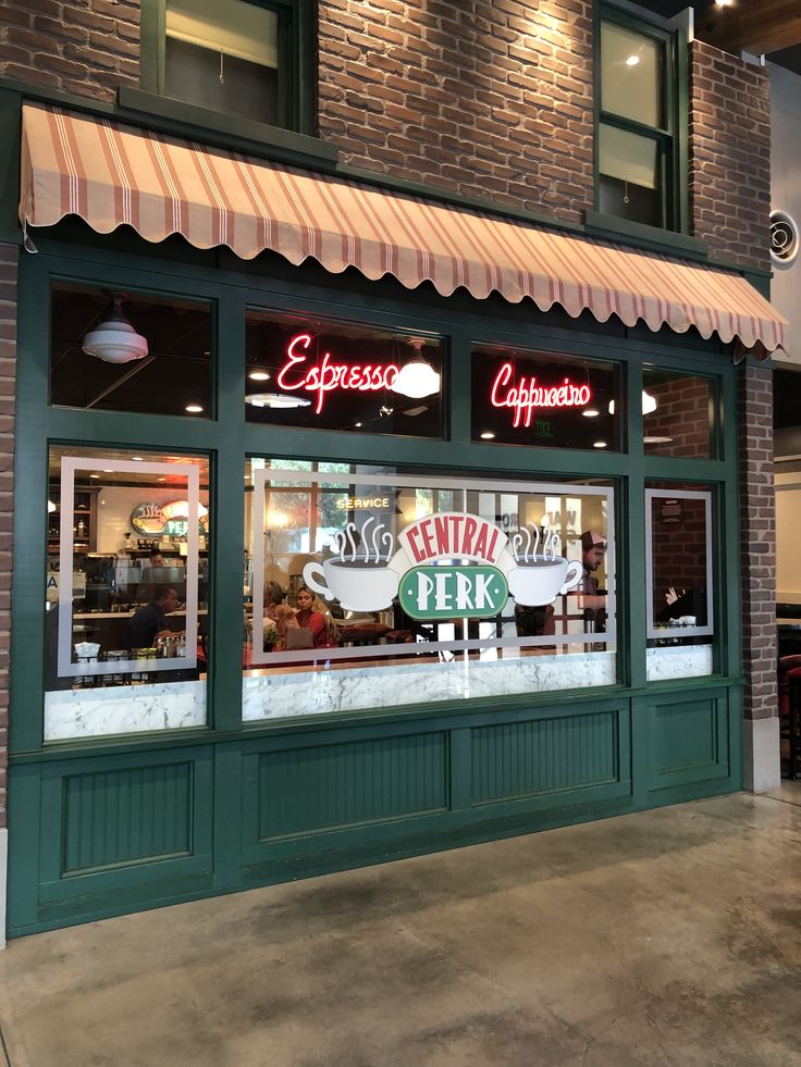 the entrance to an eatery restaurant with green trim and awnings on brick building