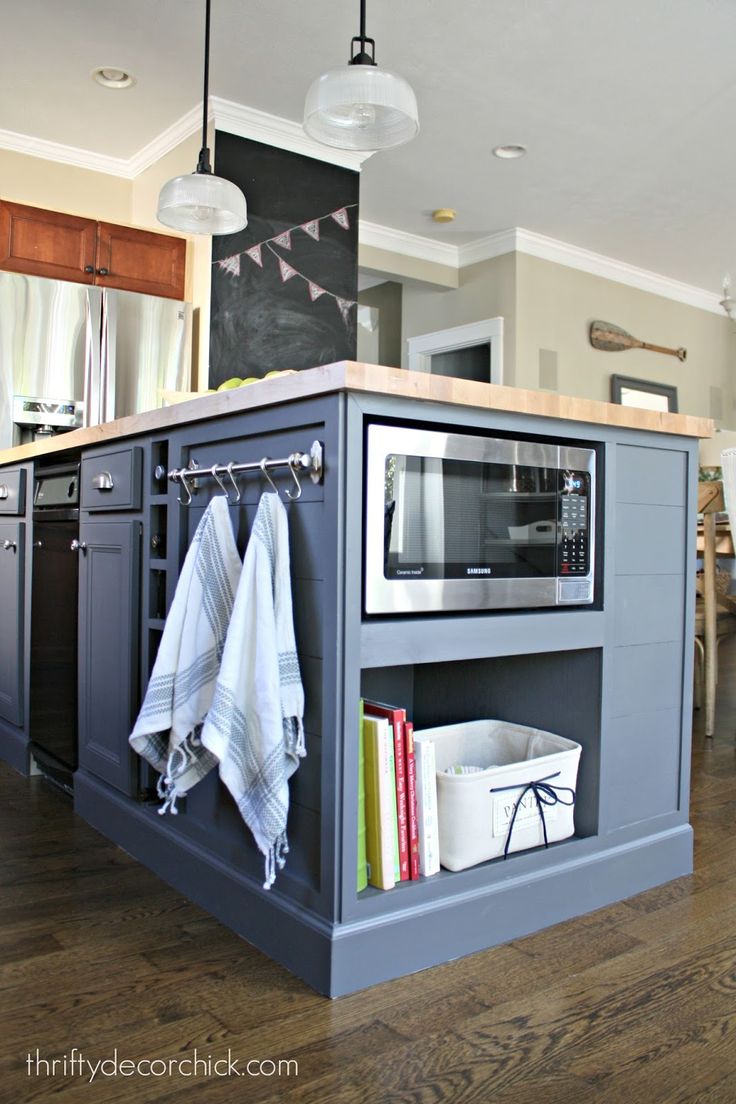 a kitchen island with an oven and microwave in it