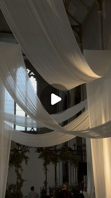 the inside of a building with white draping