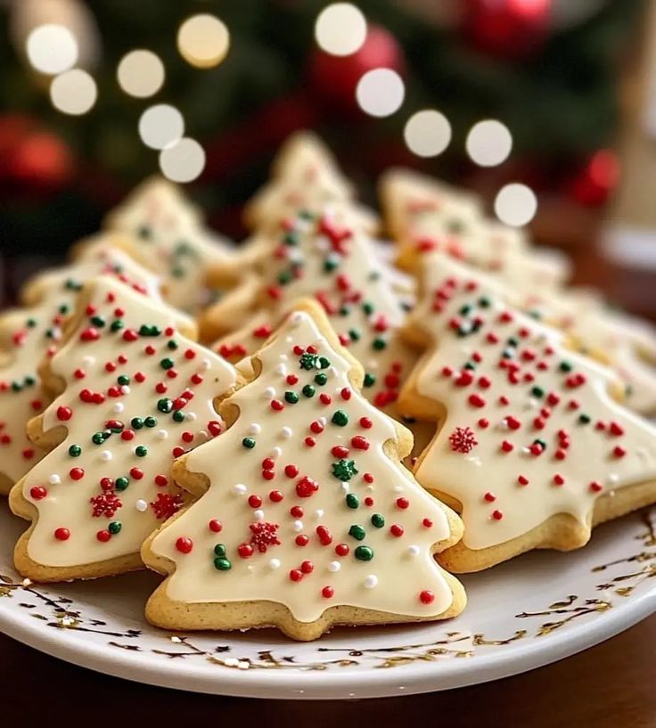 decorated christmas tree cookies on a white plate