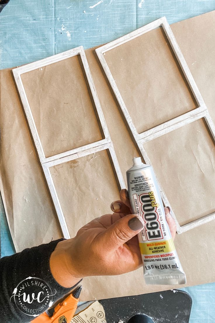 a person is holding a glue bottle and some construction materials on top of a table