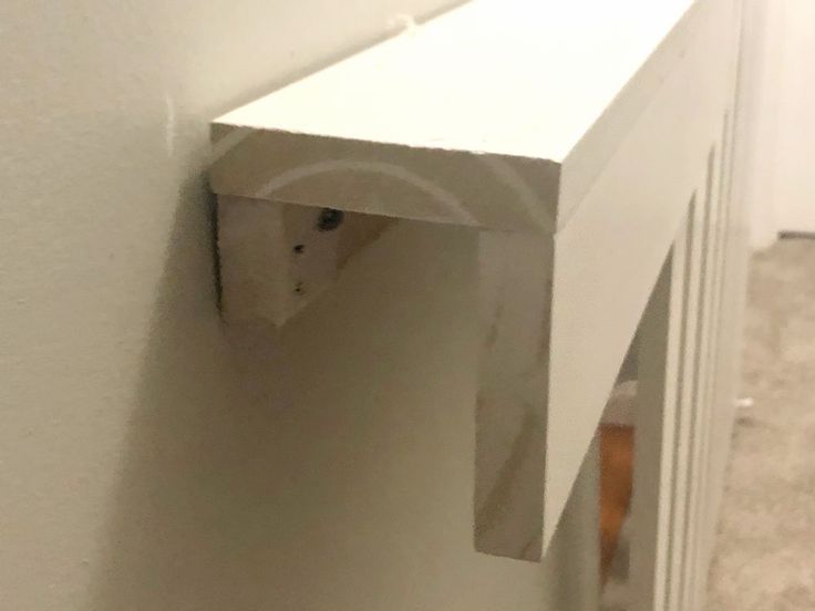 a cat peeking through the corner of a wall