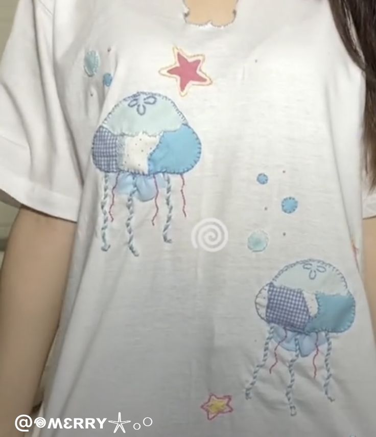 a woman wearing a t - shirt with an image of two jellyfishs on it