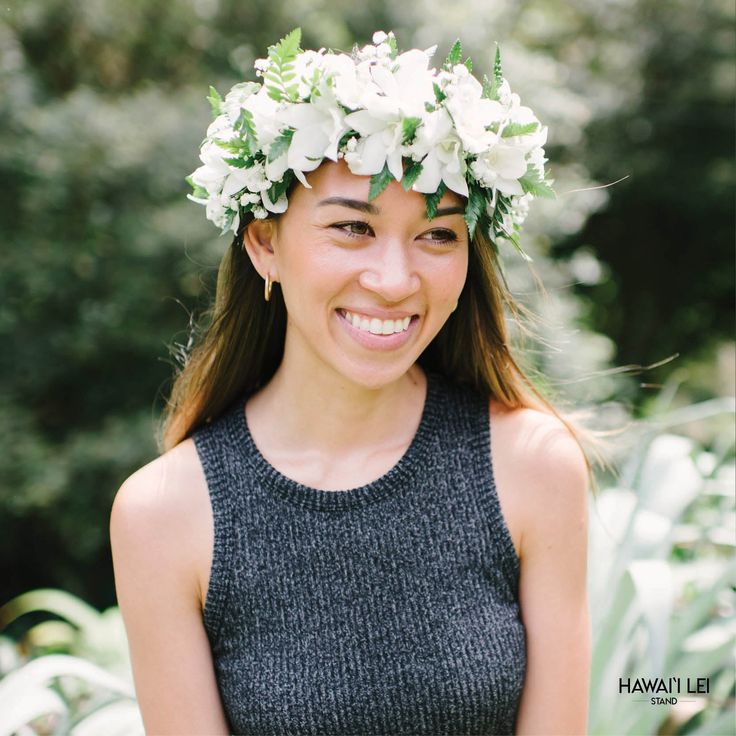 a woman wearing a flower crown smiling at the camera