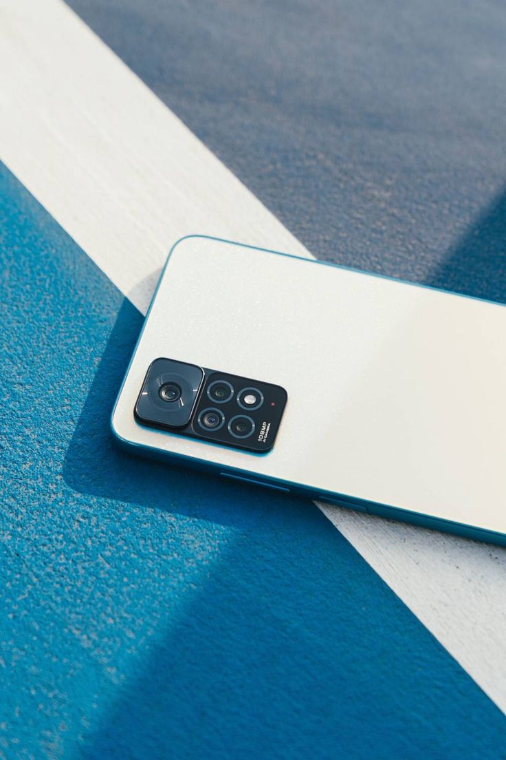 a close up of a cell phone on a blue and white striped surface with two buttons