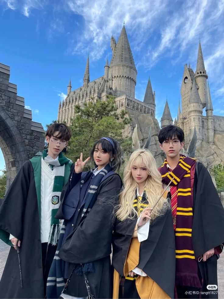 three people are posing in front of hogwart's castle at the wizarding world