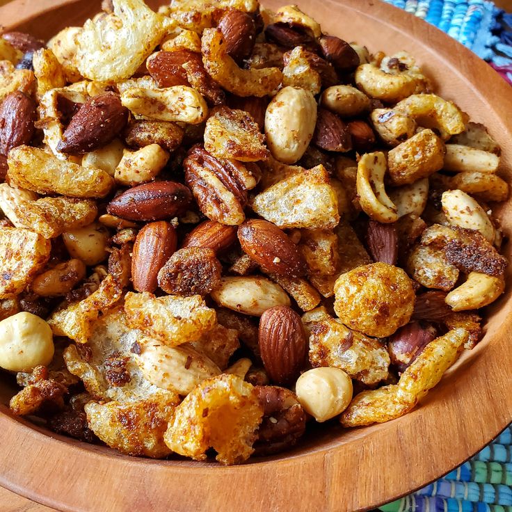 a wooden bowl filled with nuts on top of a table