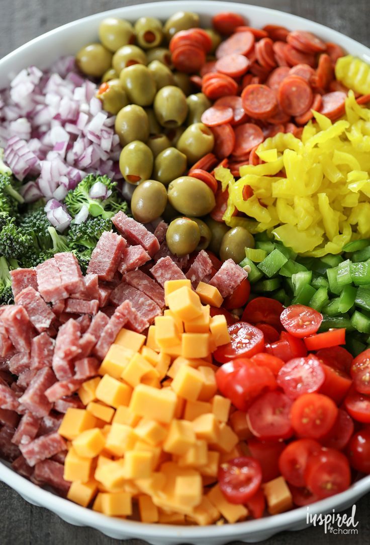 a large bowl filled with different types of vegetables and meats on top of each other