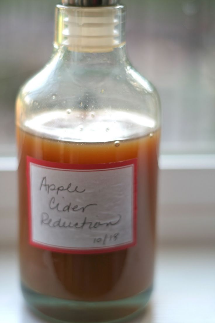 an apple cider distillator in a glass bottle on a window sill